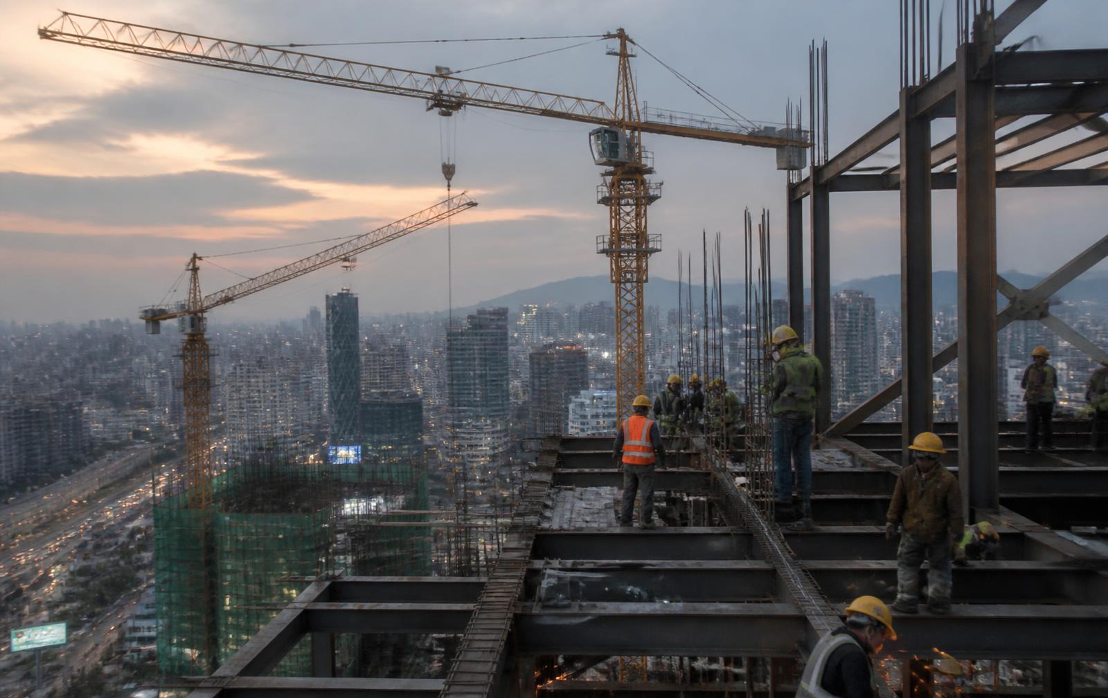 Structural steel frame and tower cranes on a city construction site at dusk in Addis Ababa