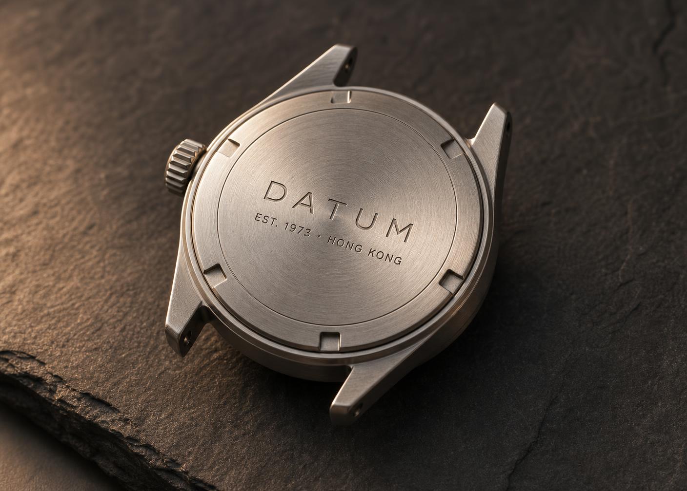 Brushed stainless steel caseback laser-engraved with the Datum name and 1973 founding year